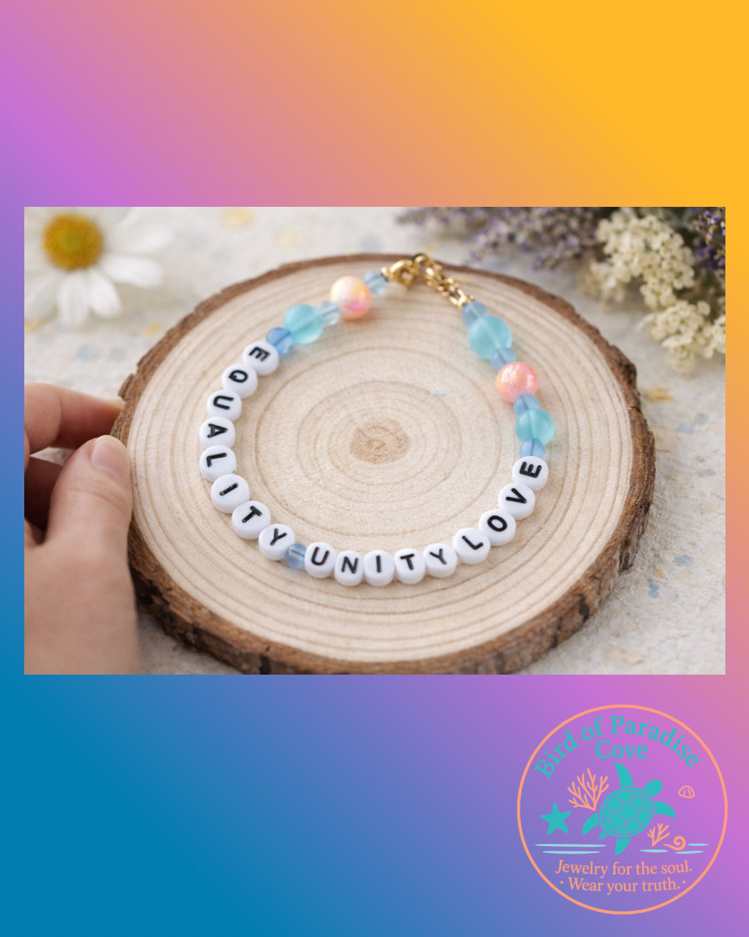 Handmade Equality Love Unity bracelet photographed in hand on a wood slice, showing scale and clasp detail in a warm lifestyle setting.