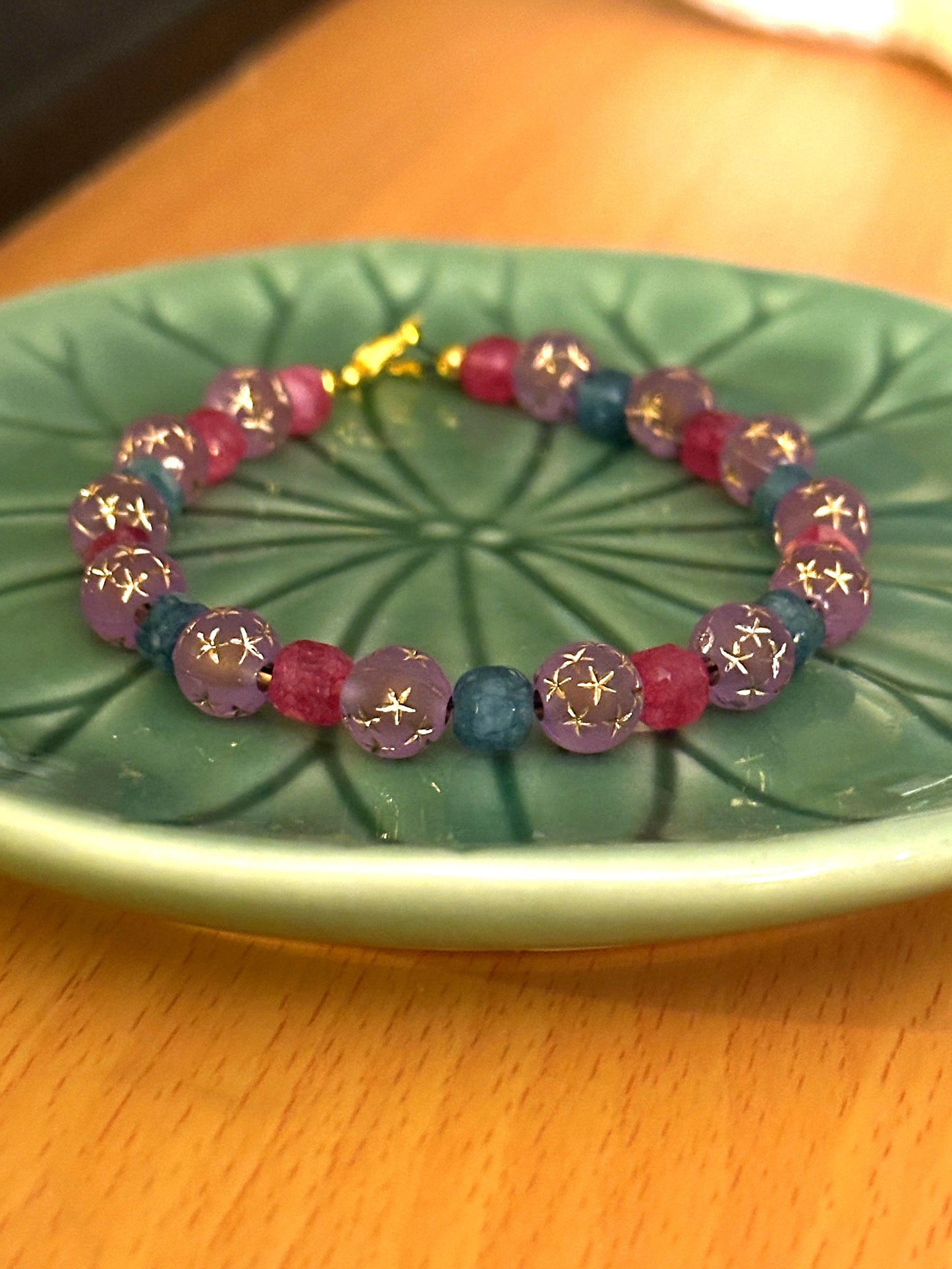 Detailed flat lay of a lavender, teal, and pink gemstone bracelet emphasizing bead texture and color balance.