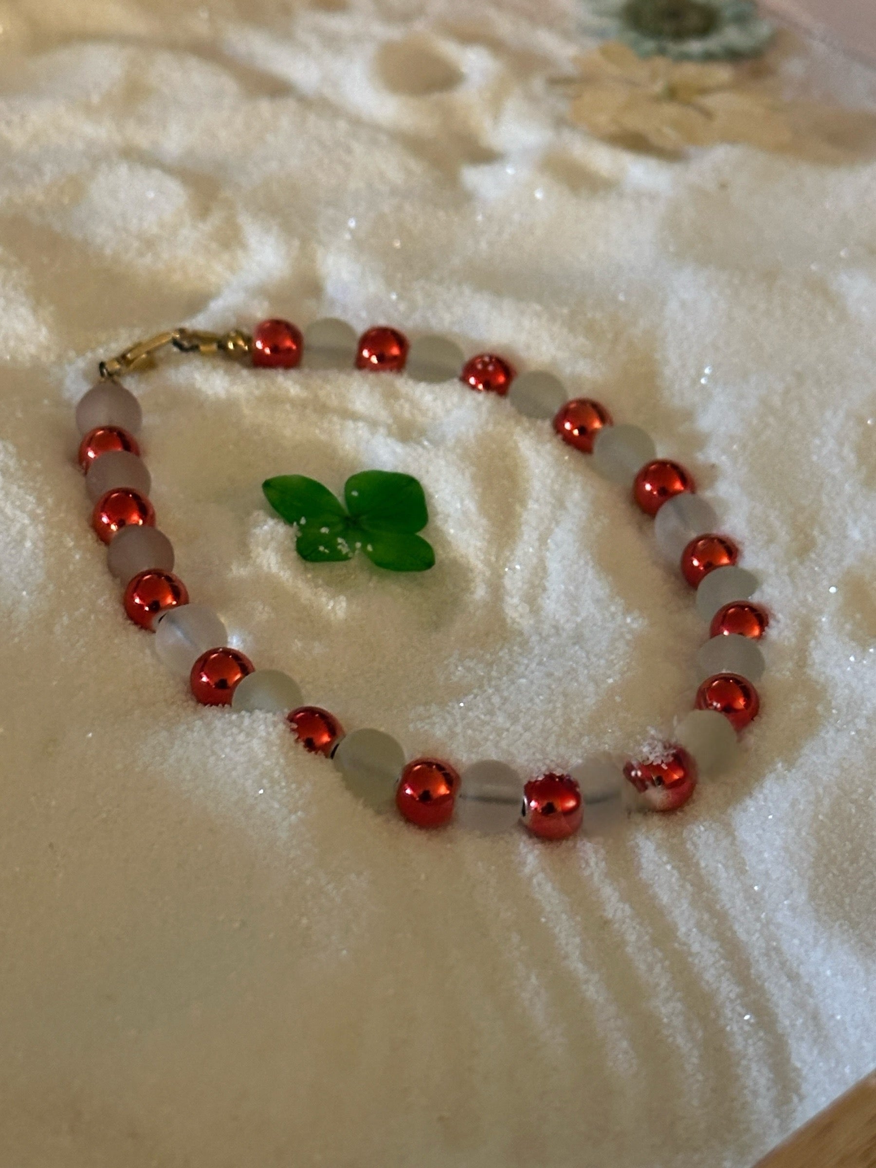 Blush and rose bead bracelet styled on a pink floral background for a soft, romantic gift presentation.
