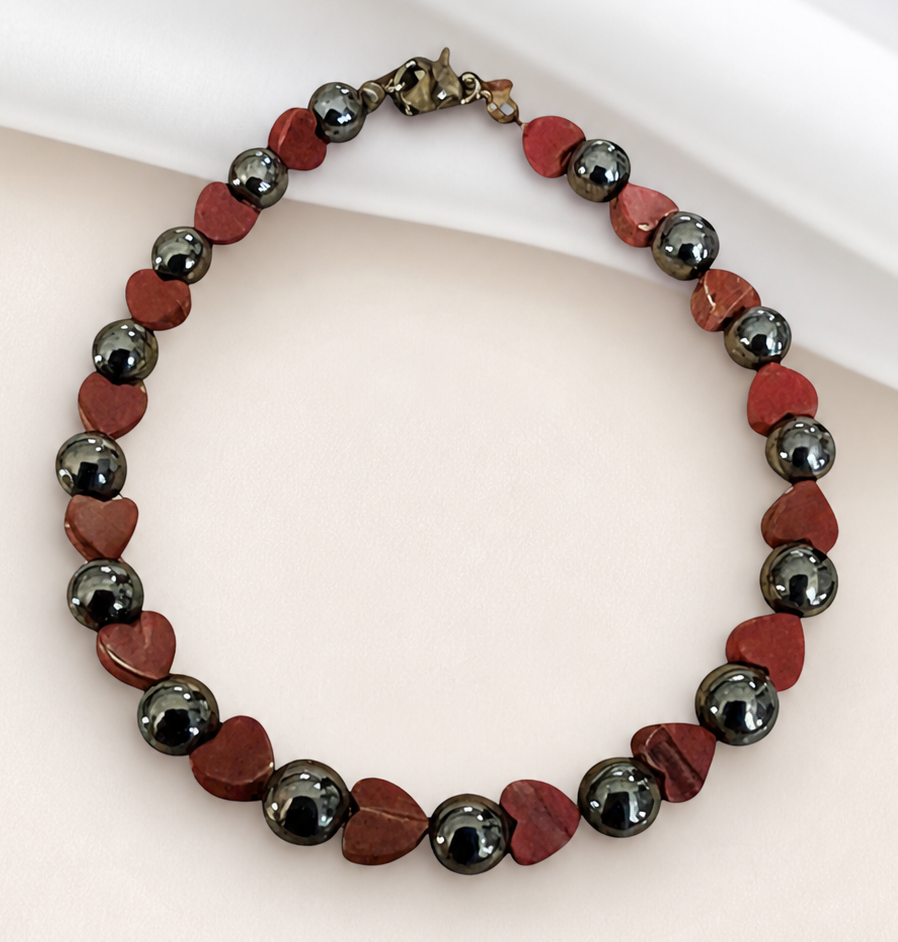 Hematite heart bracelet for strength and stability on clean neutral background