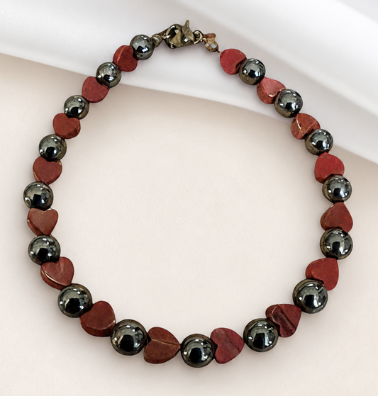 Hematite heart bracelet for strength and stability on clean neutral background