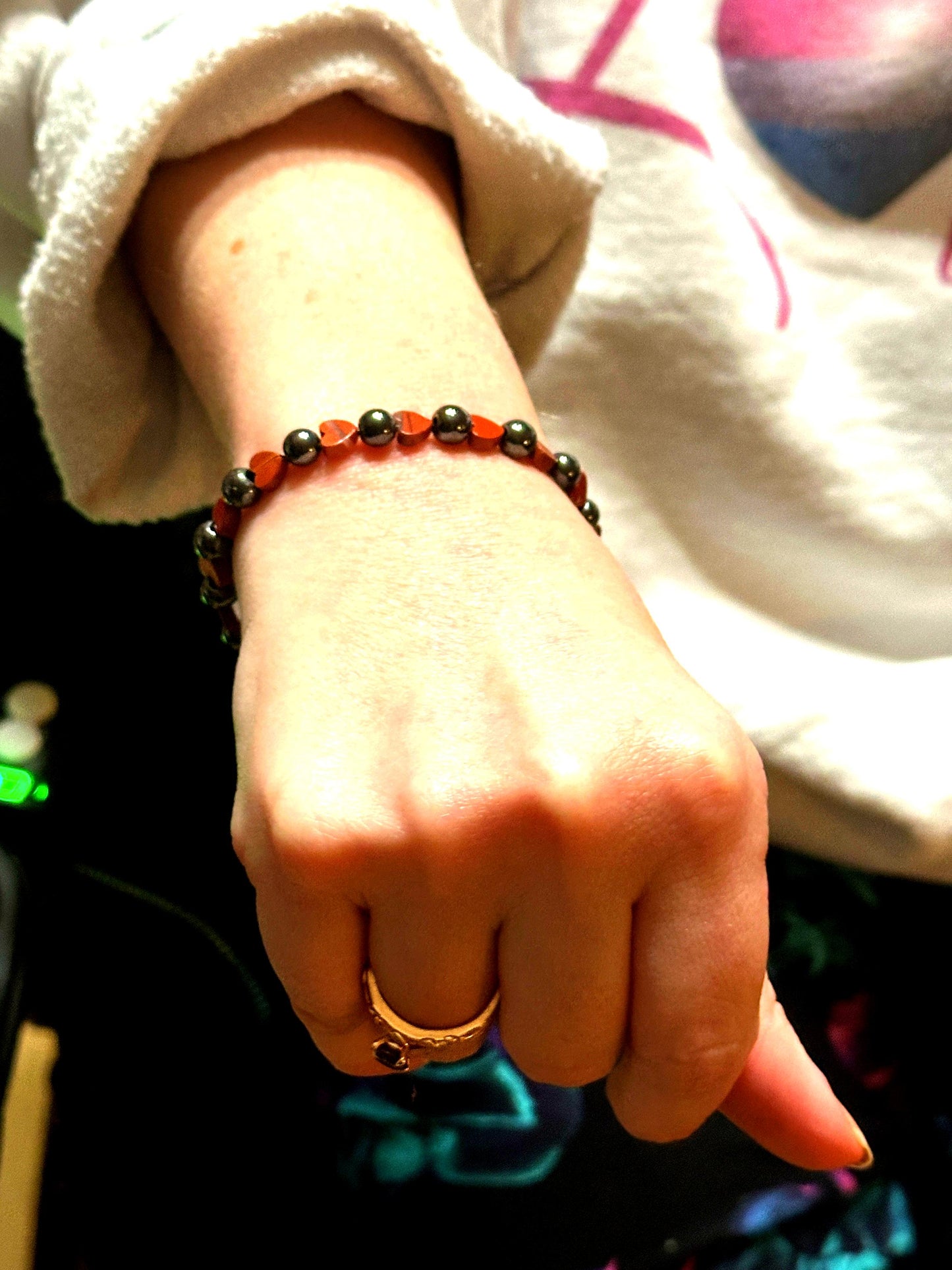 Woman wearing hematite heart bracelet for grounding and emotional balance