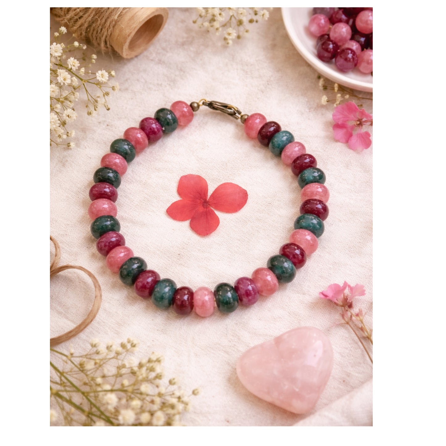 Multicolored beaded bracelet on a textured surface with flowers and a heart.