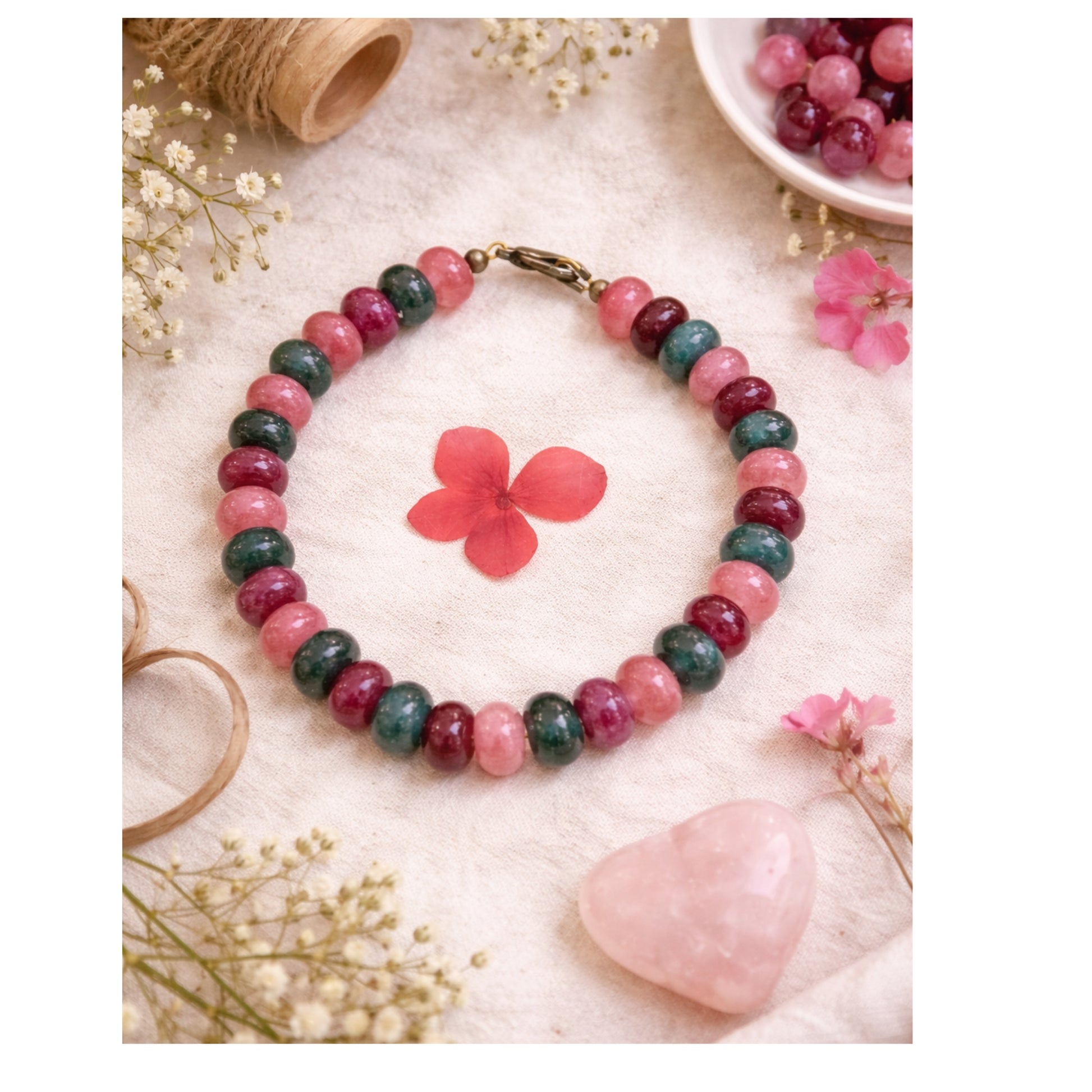 Multicolored beaded bracelet on a textured surface with flowers and a heart.