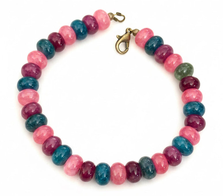 Handmade Between The Waves bracelet featuring pink, berry, and teal rondelle gemstone beads with bronze lobster clasp on a white background.