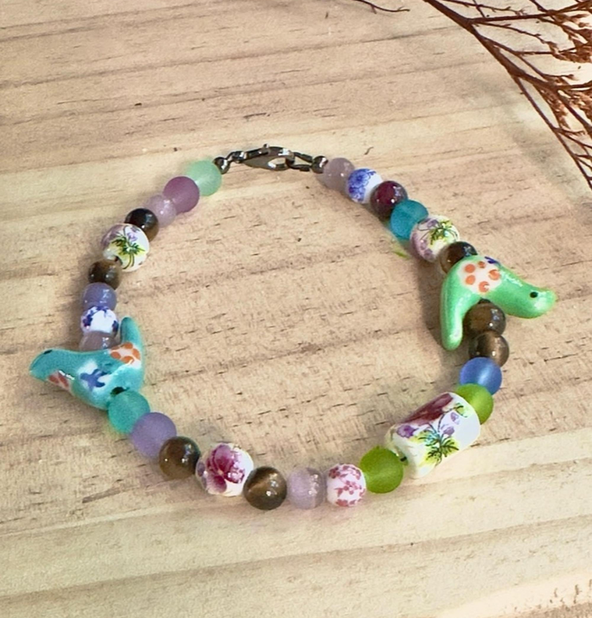 Full view of Bird-Eye View handmade bracelet with colorful mixed beads, flowers and whimsical turquoise birds.