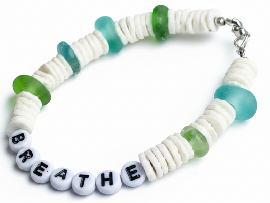 Bracelet with beads spelling 'BREATHE' on a wooden surface