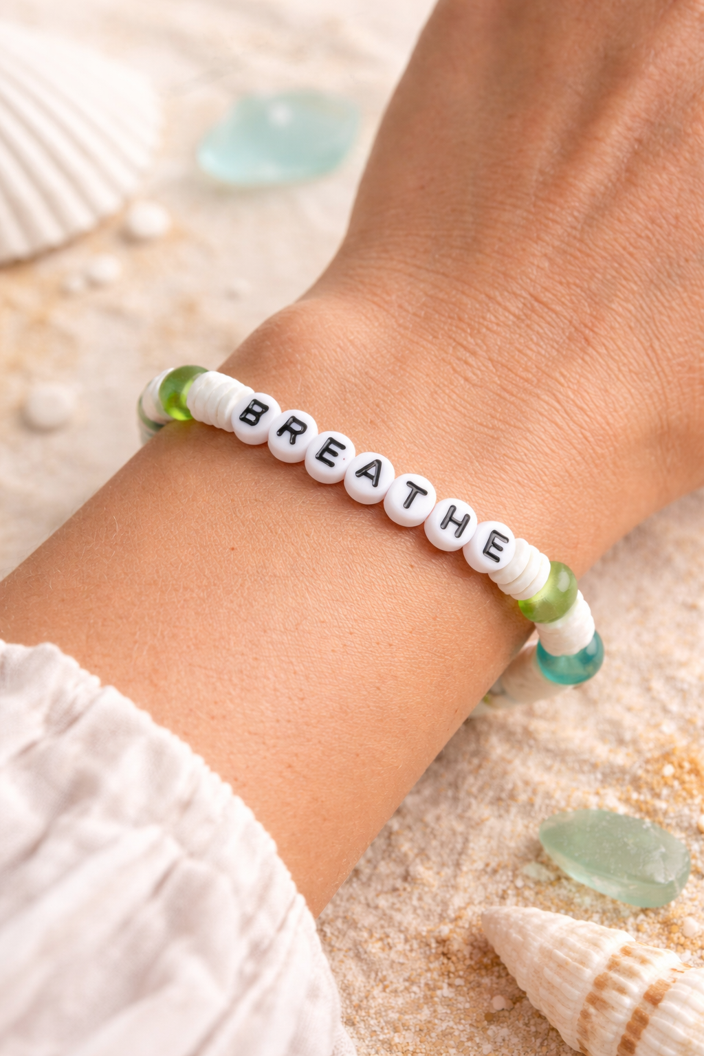 Bracelet with 'BREATHE' beads on a wrist against a natural background