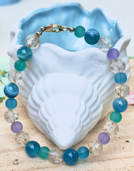 Multicolored beaded bracelet on a white shell with a natural background