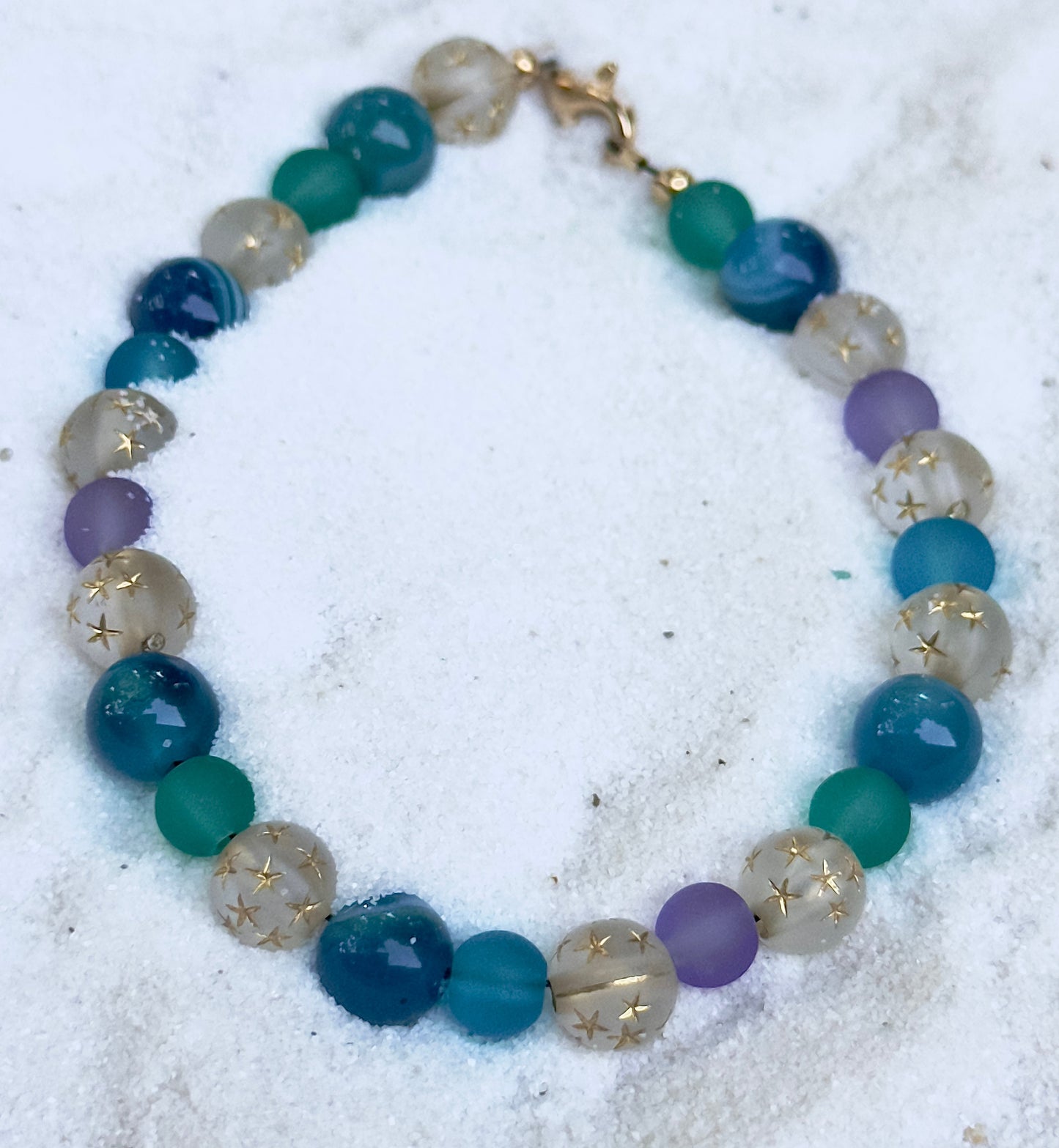 Multicolored beaded bracelet on a sandy background