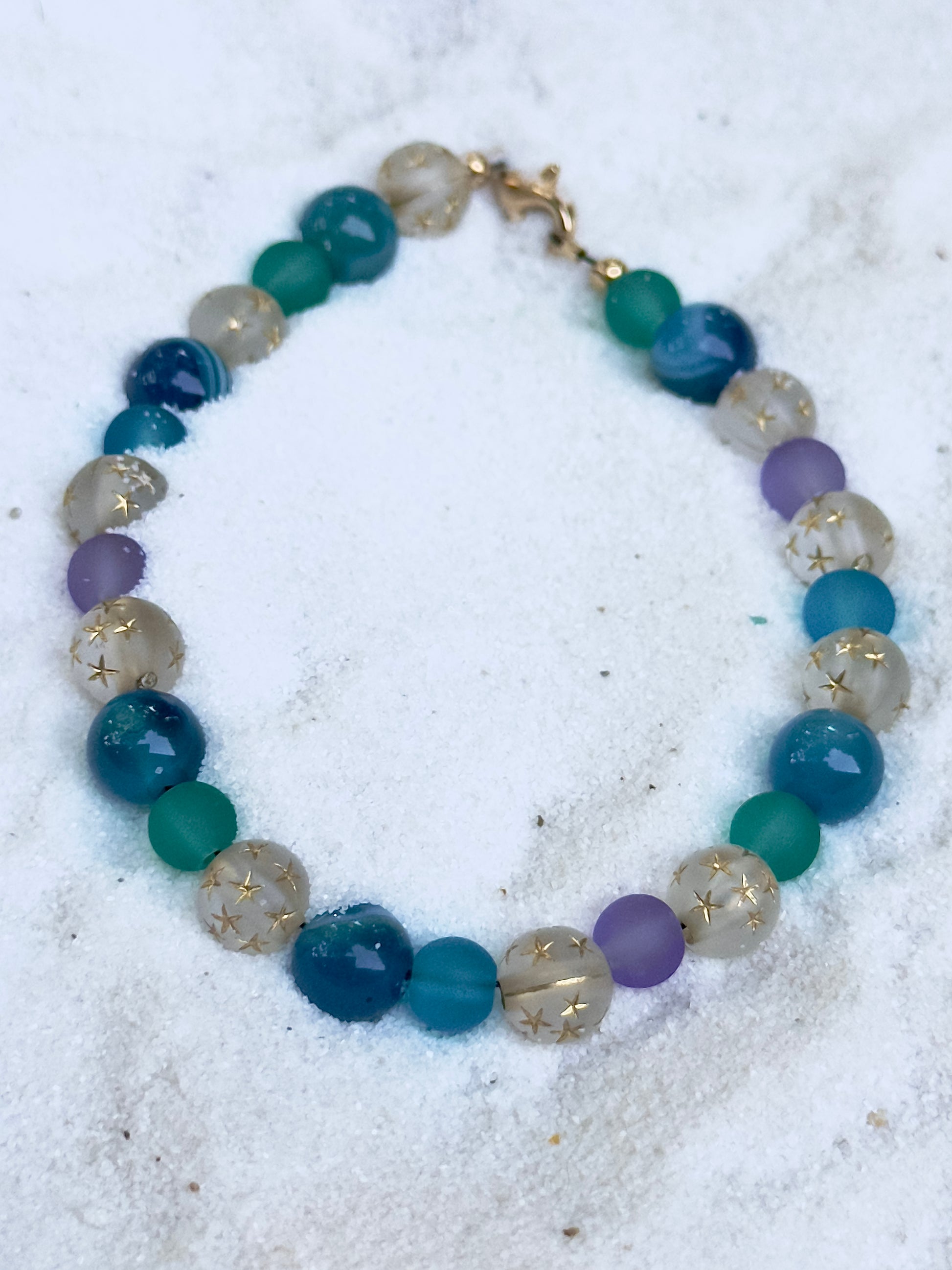 Close-up of Celestial Opalite Sky bracelet beads showing opalite shimmer, blue tones, and star-pattern accents
