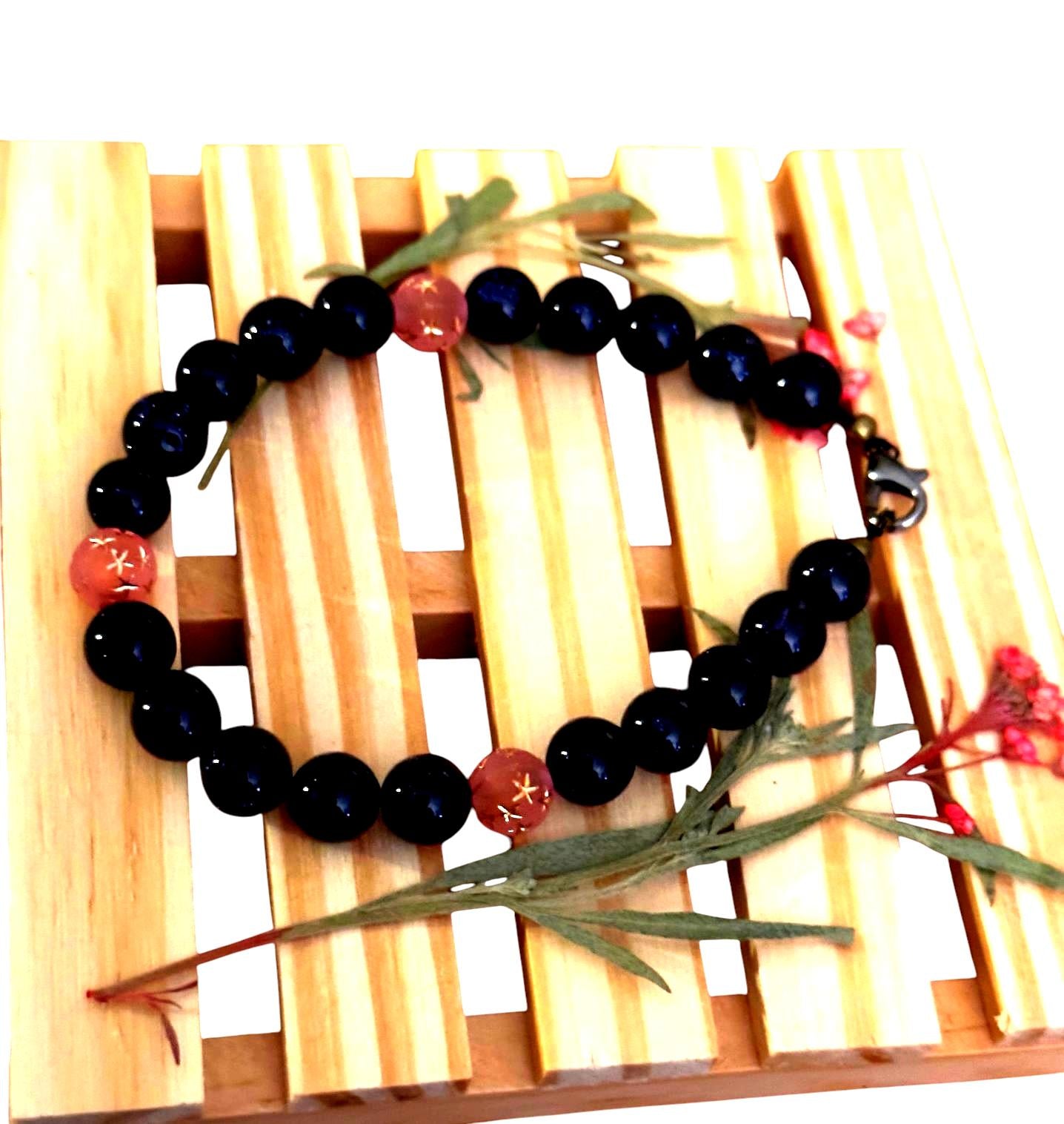 Close-up of sandstone and pink star-etched beads on a celestial bracelet, showing shimmer, texture, and handcrafted details