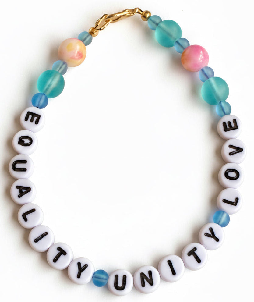 Equality Unity Love beaded bracelet with pastel blue pink and teal beads on neutral background minimalist jewelry photo