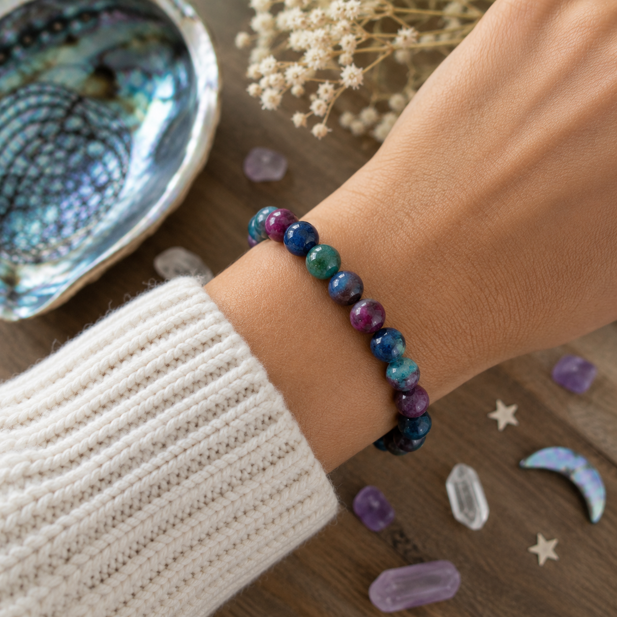 Colorful handmade gemstone bracelet worn with cozy cream sweater in boho lifestyle setting