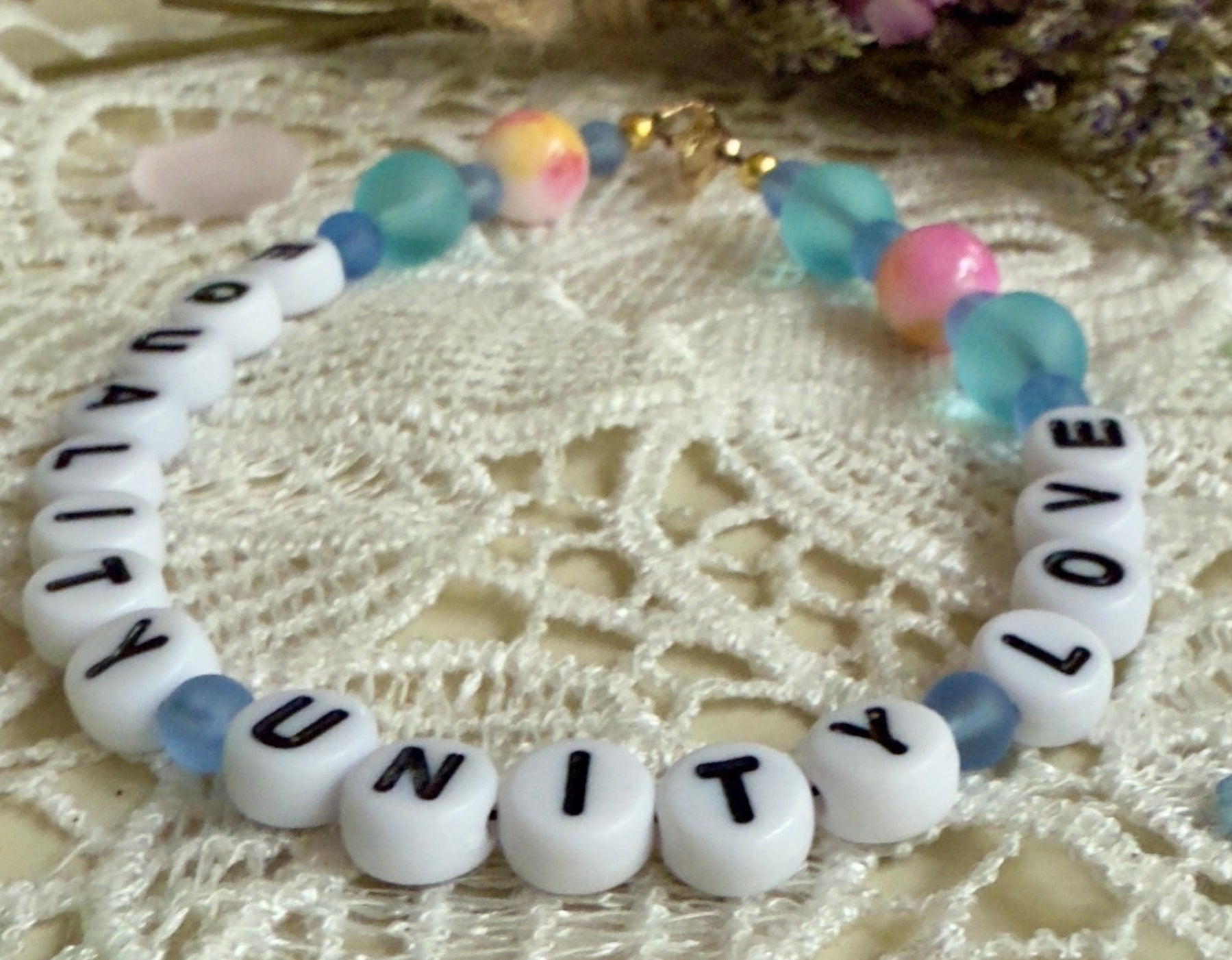 close up of Unity letter beads with pastel blue gemstone beads handmade bracelet detail sho