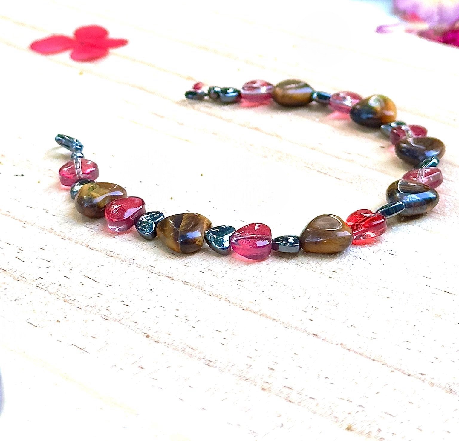 Full view of handmade heart gemstone bracelet with Tiger Eye and pink glass beads on a light surface
