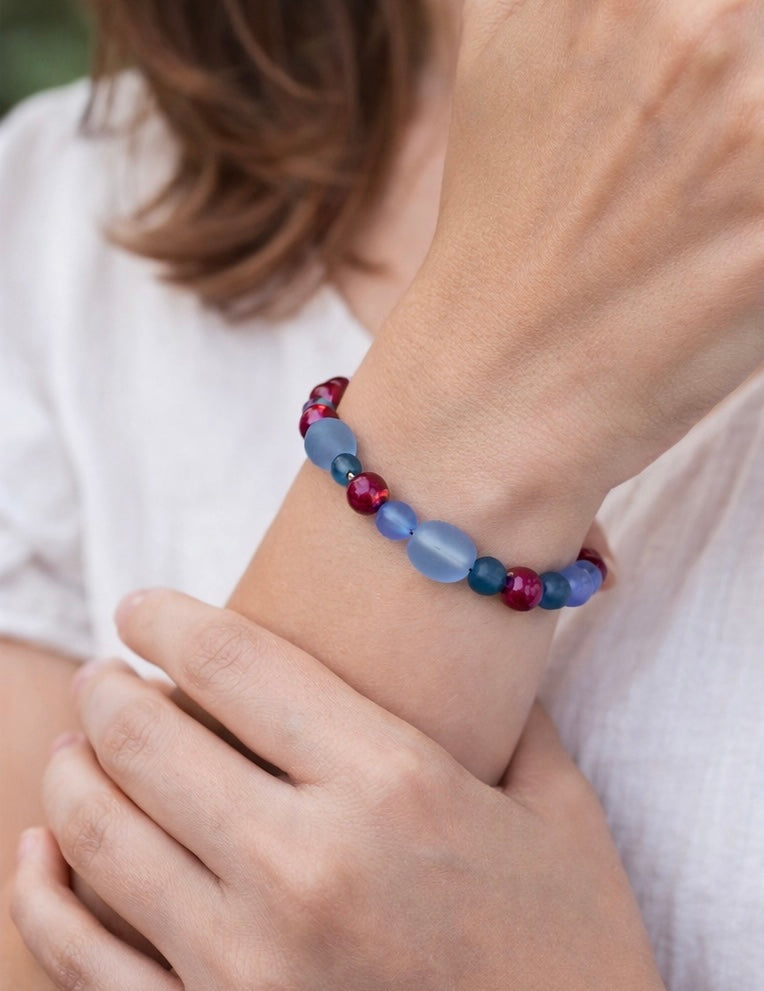 Woman wearing a blue and pink beaded bracelet on her wrist, showing fit, scale, and everyday wear style.