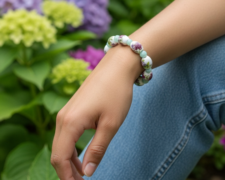 Hidden Reverie Meadow bracelet worn on the wrist in a garden setting surrounded by blooming flowers.