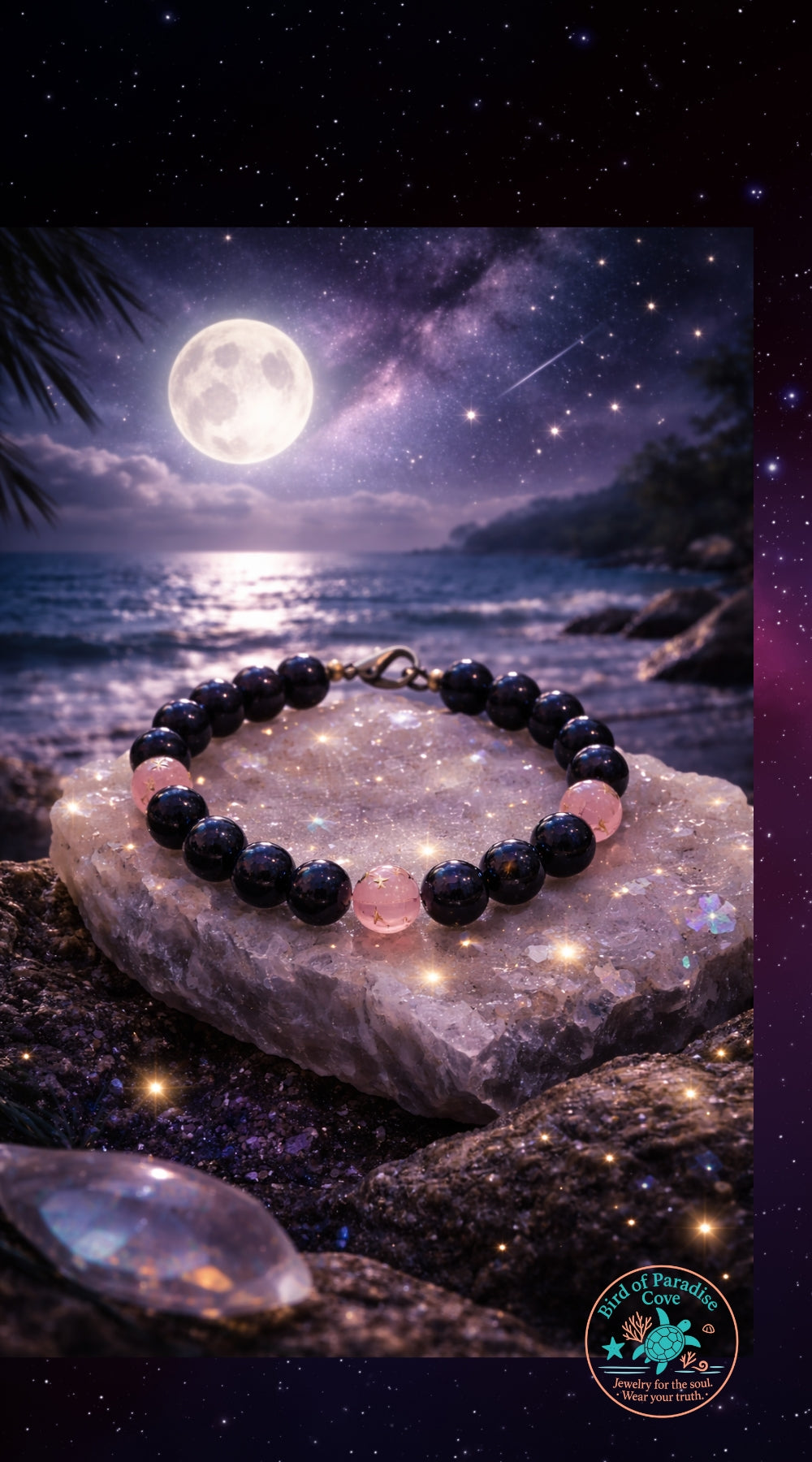 Celestial beaded bracelet displayed on a crystal by the ocean under moonlight, featuring dark blue sandstone and pink star-etched beads with a starry night sky and inspirational quote