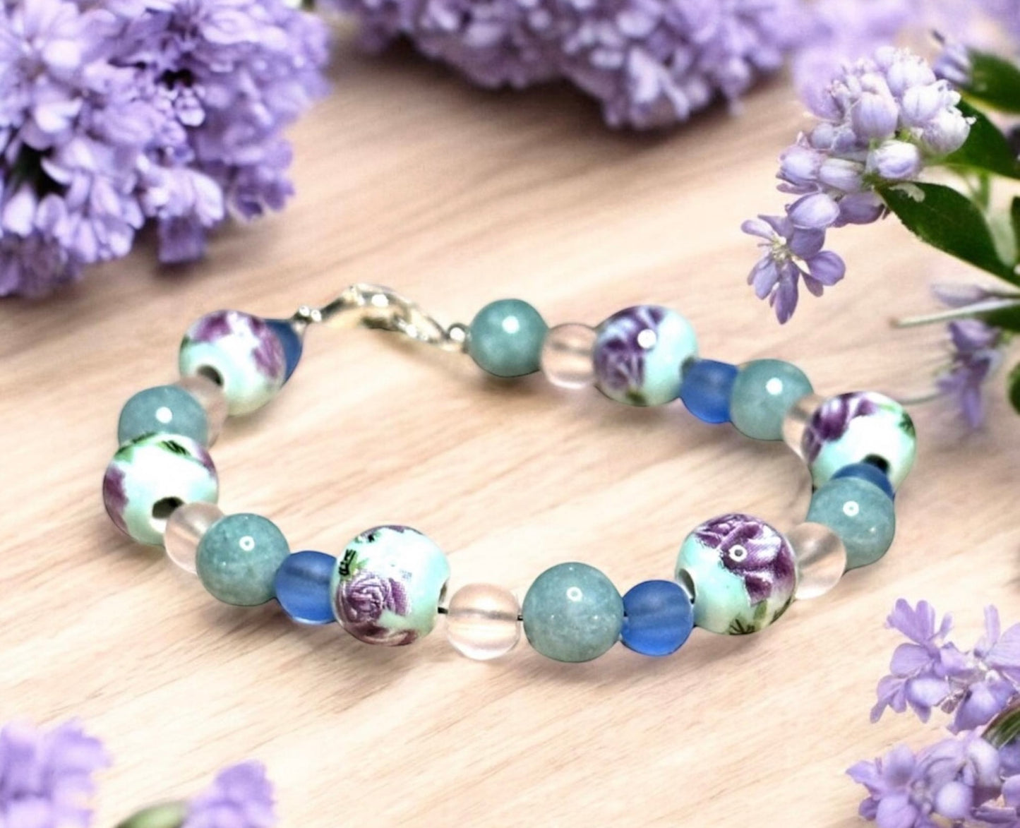 Dreamy floral coastal bracelet styled with lavender flowers, seashells, and calming cottagecore decor