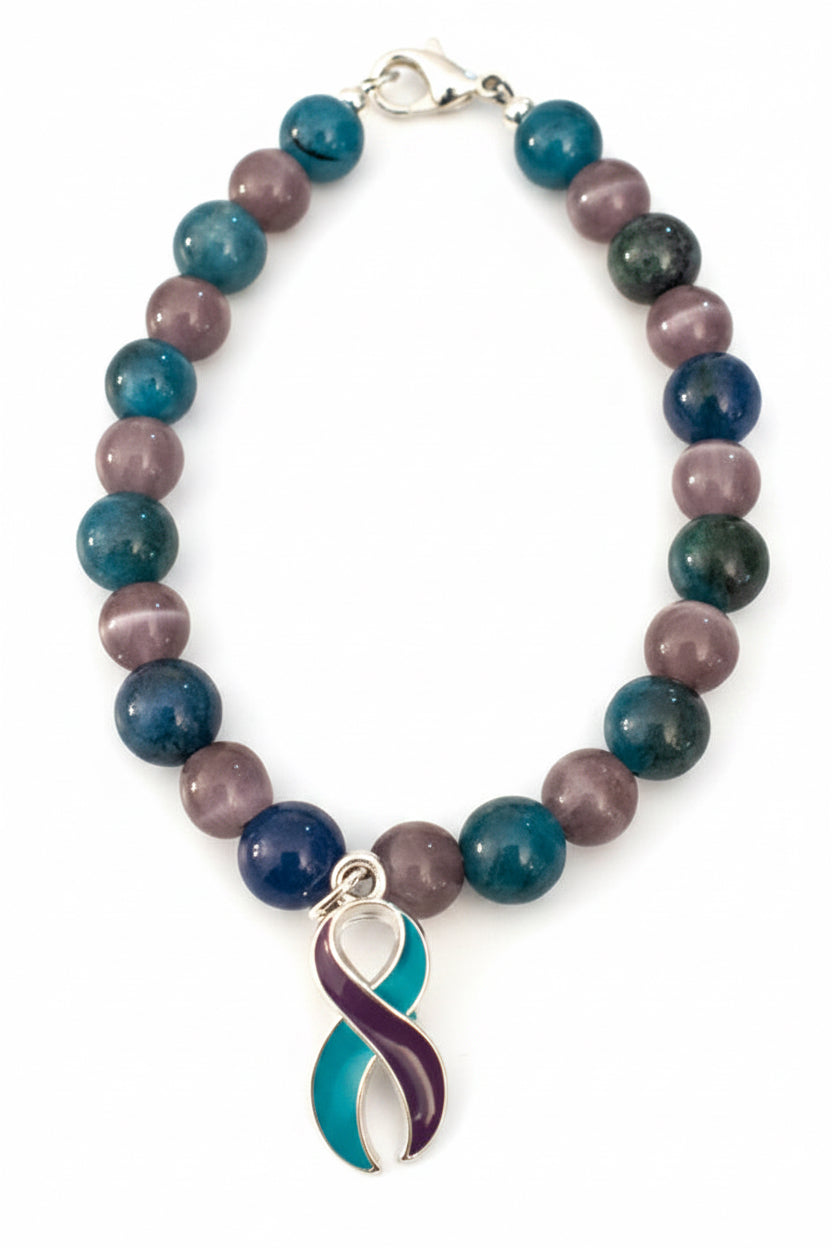 Light After Darkness awareness bracelet with blue, teal, purple and green gemstone beads and a teal and purple awareness ribbon charm.
