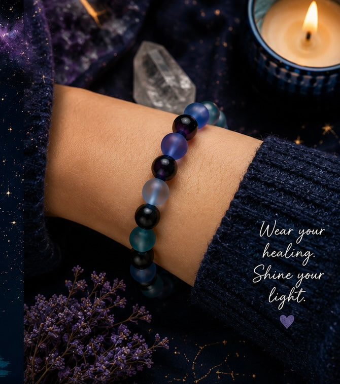 Person wearing the Lunar Twilight Galaxy handmade gemstone bracelet with calming blue, teal, purple, gray, and black beads against a cozy celestial-inspired setting.