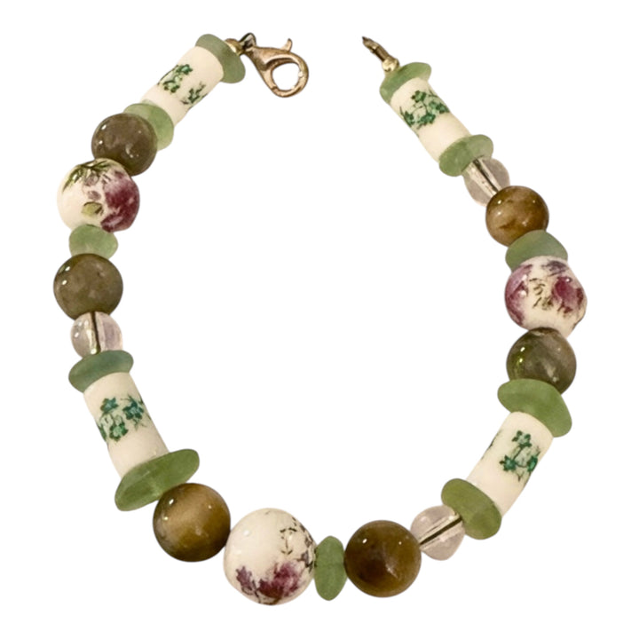 Meadowlight Garden of Stillness bracelet with earthy green, cream and floral beads on a white background.