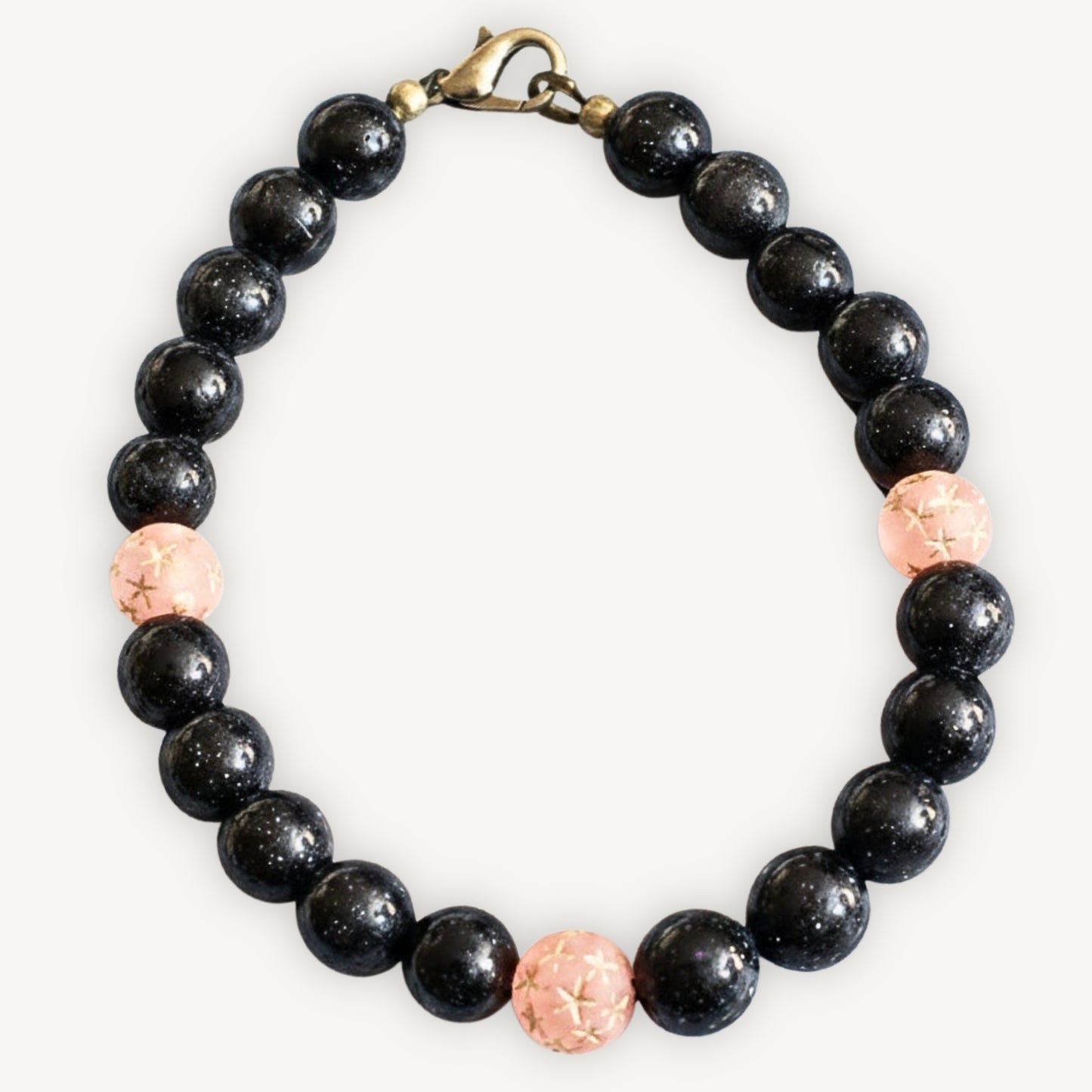Blue sandstone beaded bracelet with pink Star gold accents on a off white background