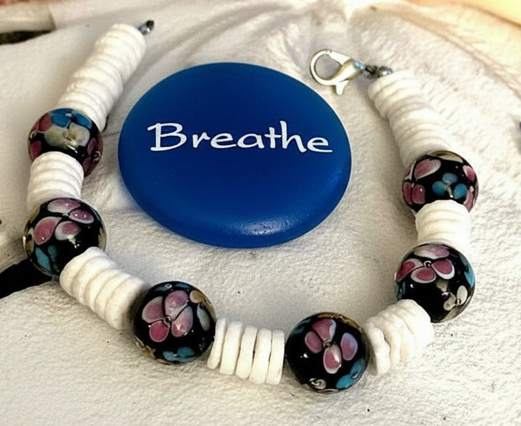 Moonlit Garden bracelet surrounding a blue stone reading “Breathe” on a pale textured surface.