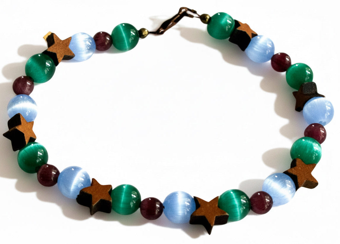 Moonstar grounding bracelet with blue green and purple cat's eye beads and wood star accents on neutral background
