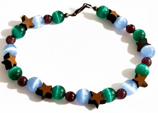Moonstar grounding bracelet with blue green and purple cat's eye beads and wood star accents on neutral background