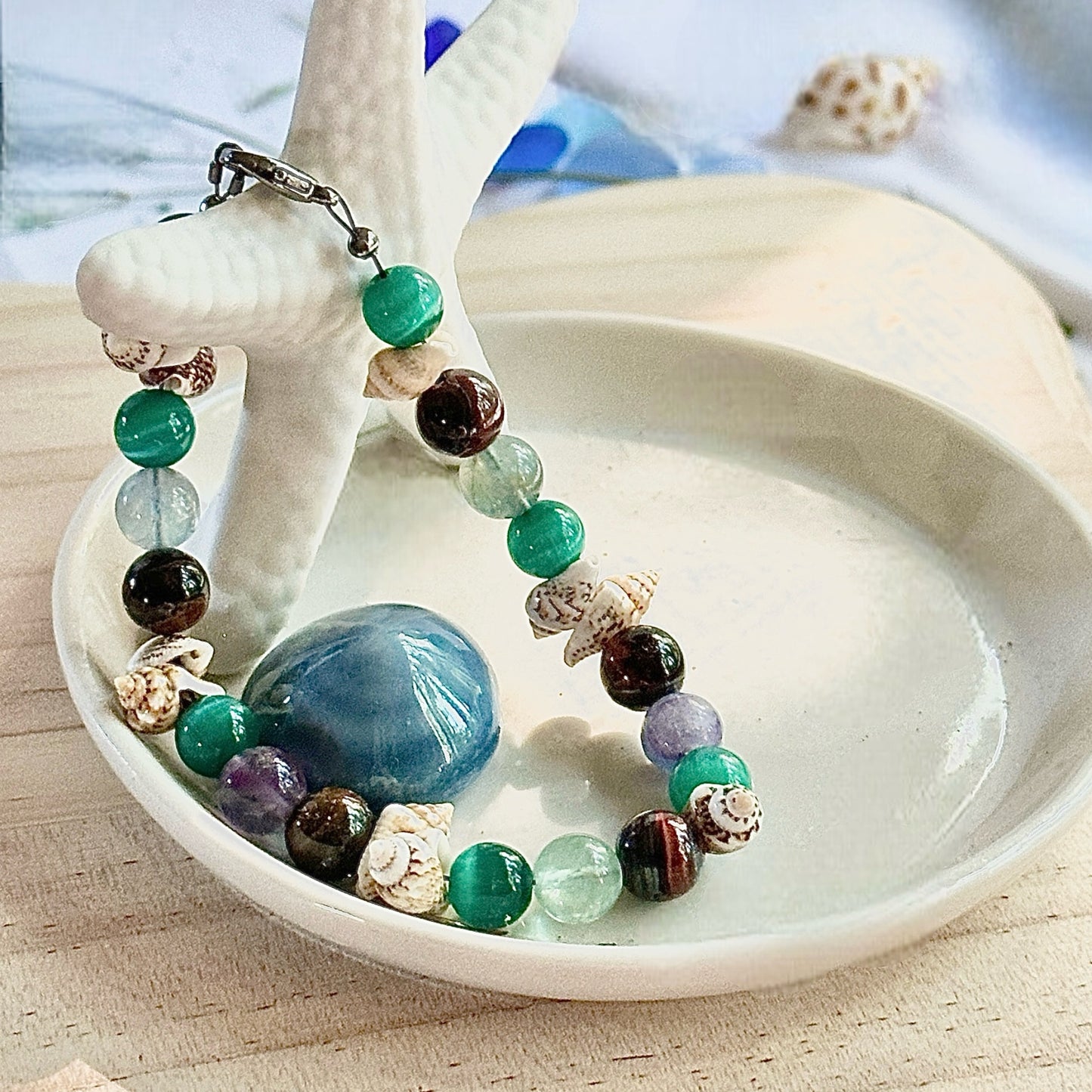 Ocean’s Treasure bracelet styled in a decorative coastal bowl with ocean-inspired accents.