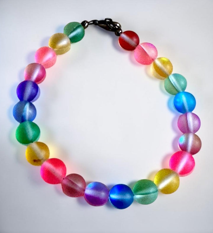Rainbow Connection Pride bracelet with colorful frosted glass beads arranged in a rainbow pattern on a clean white background.