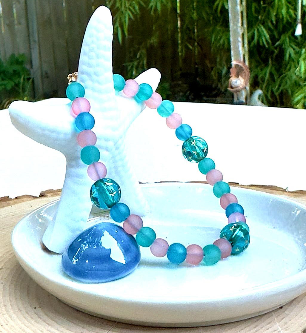 handmade seafoam stardust bracelet with glass and gemstone beads displayed on starfish ocean inspired jewelry