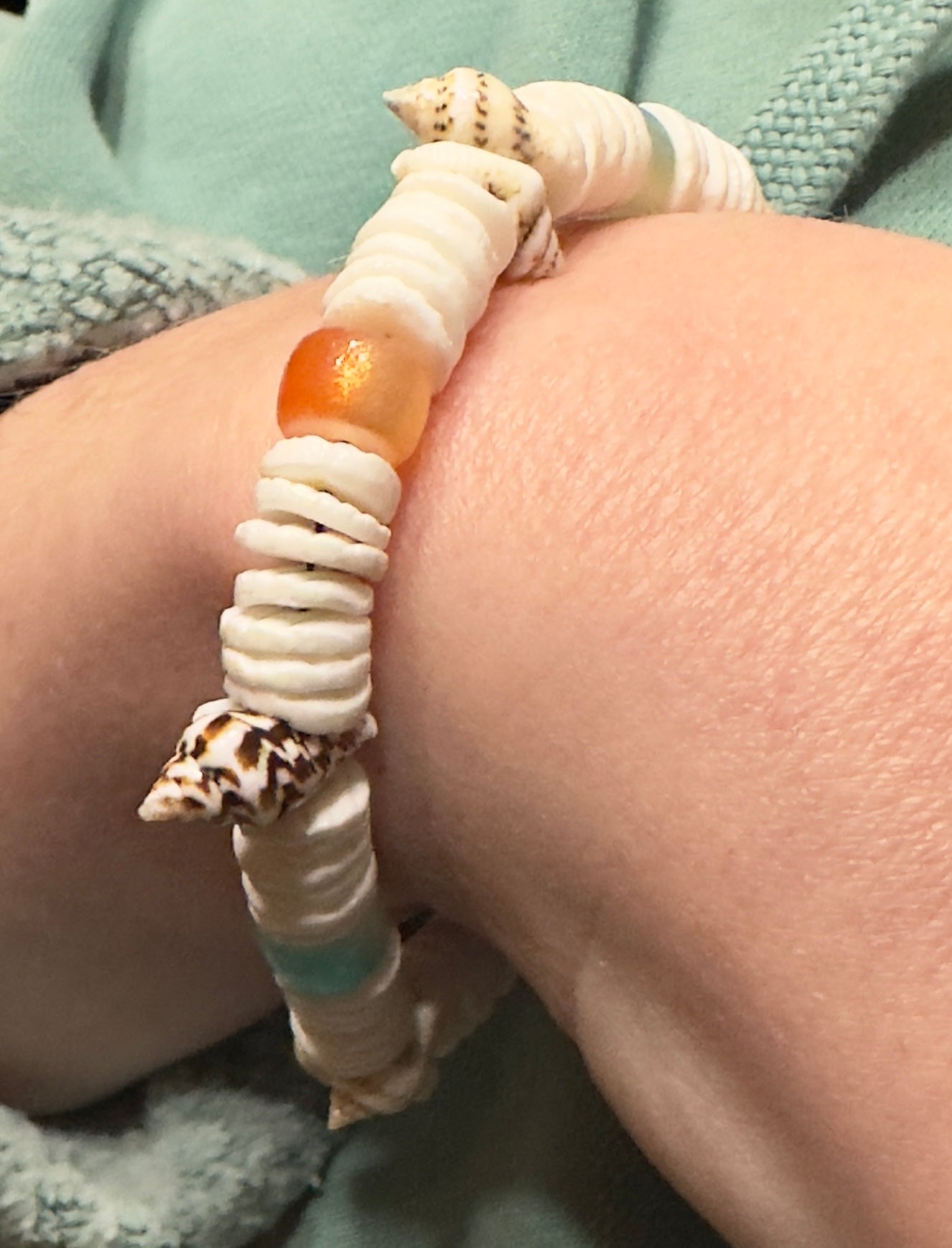 Coastal shell bracelet with heishi beads on clean white background