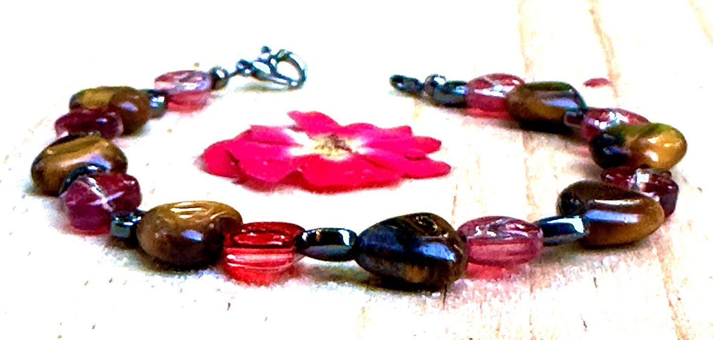 Colorful handcrafted bracelet displayed on natural wood slice with floral details