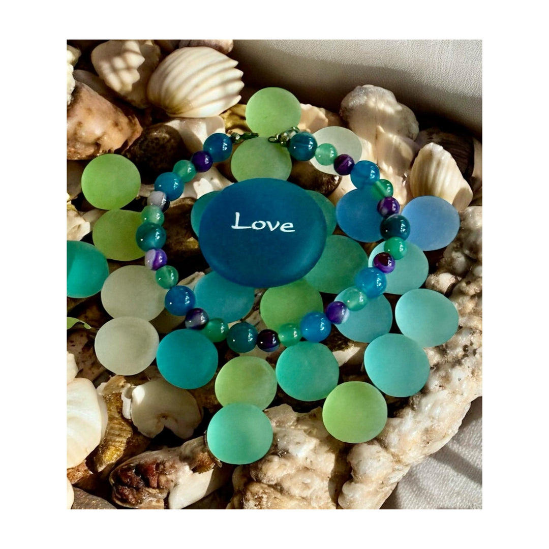     Summertide Dreams ocean-inspired bracelet worn on a wrist near the beach.