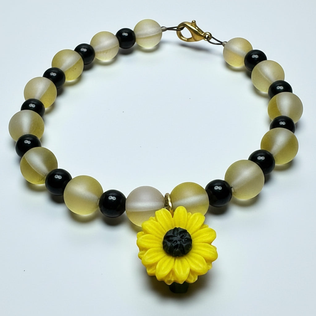 Handmade Sunflower Anchor bracelet featuring frosted yellow beads, black accent beads, iridescent beads, and a clay sunflower focal charm on a white background.
