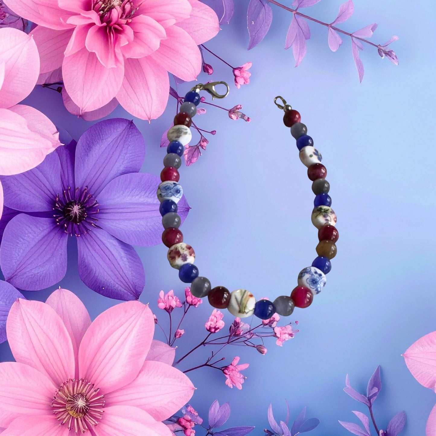     Floral bracelet lifestyle photo featuring pink and purple flowers with handmade bisexual Pride jewelry.