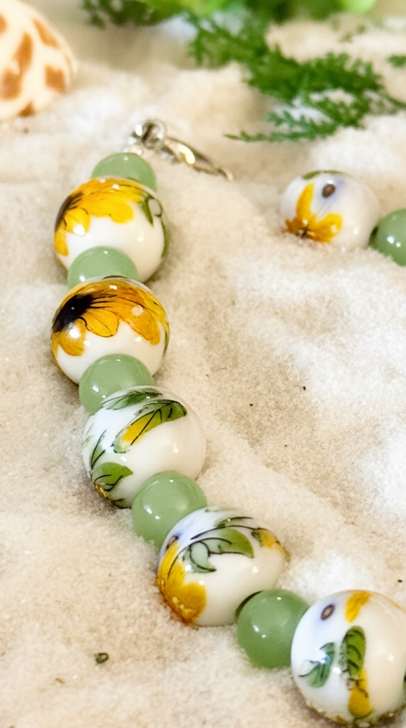 Close-up view of Wildflower Sunlight bracelet showcasing sunflower porcelain beads and pale green glass beads.