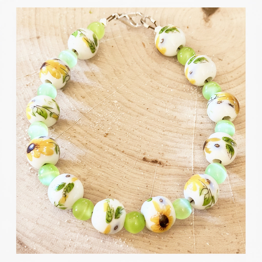 Sunflower garden bracelet displayed on a natural wood slice with floral-inspired porcelain beads.