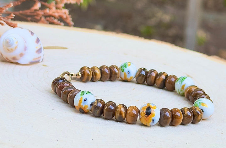 Bracelet with brown beads and colorful accents on a wooden surface with a blurred natural background