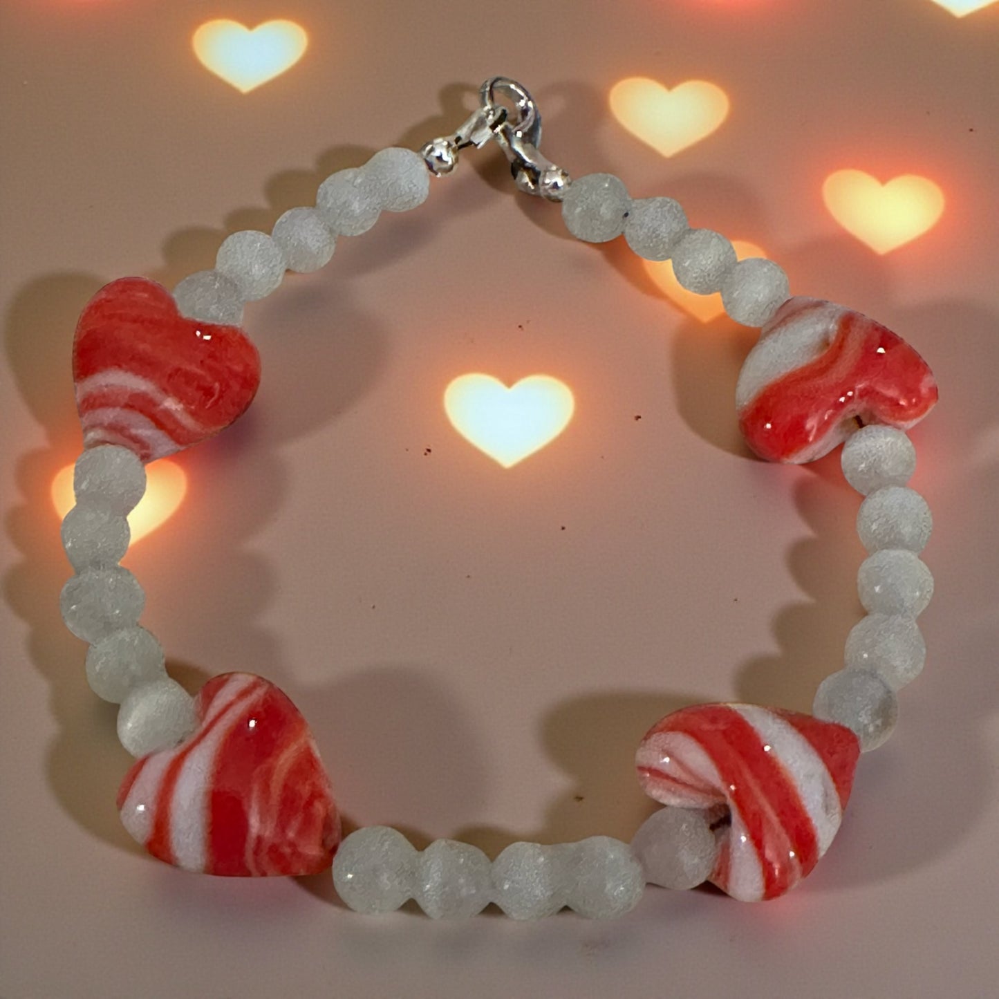 Valentine-inspired heart bead bracelet with glowing heart light background.